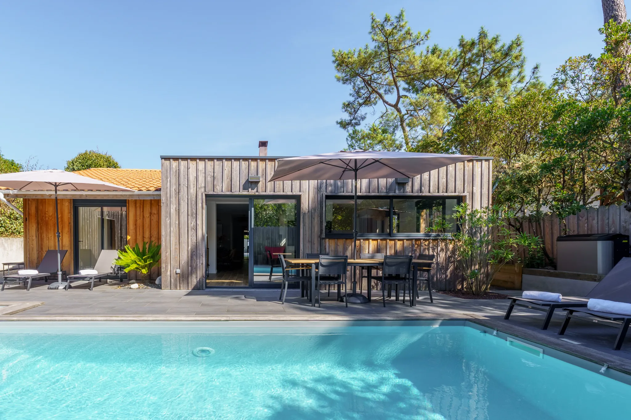 Maison devanture en bois, terrasse avec piscine