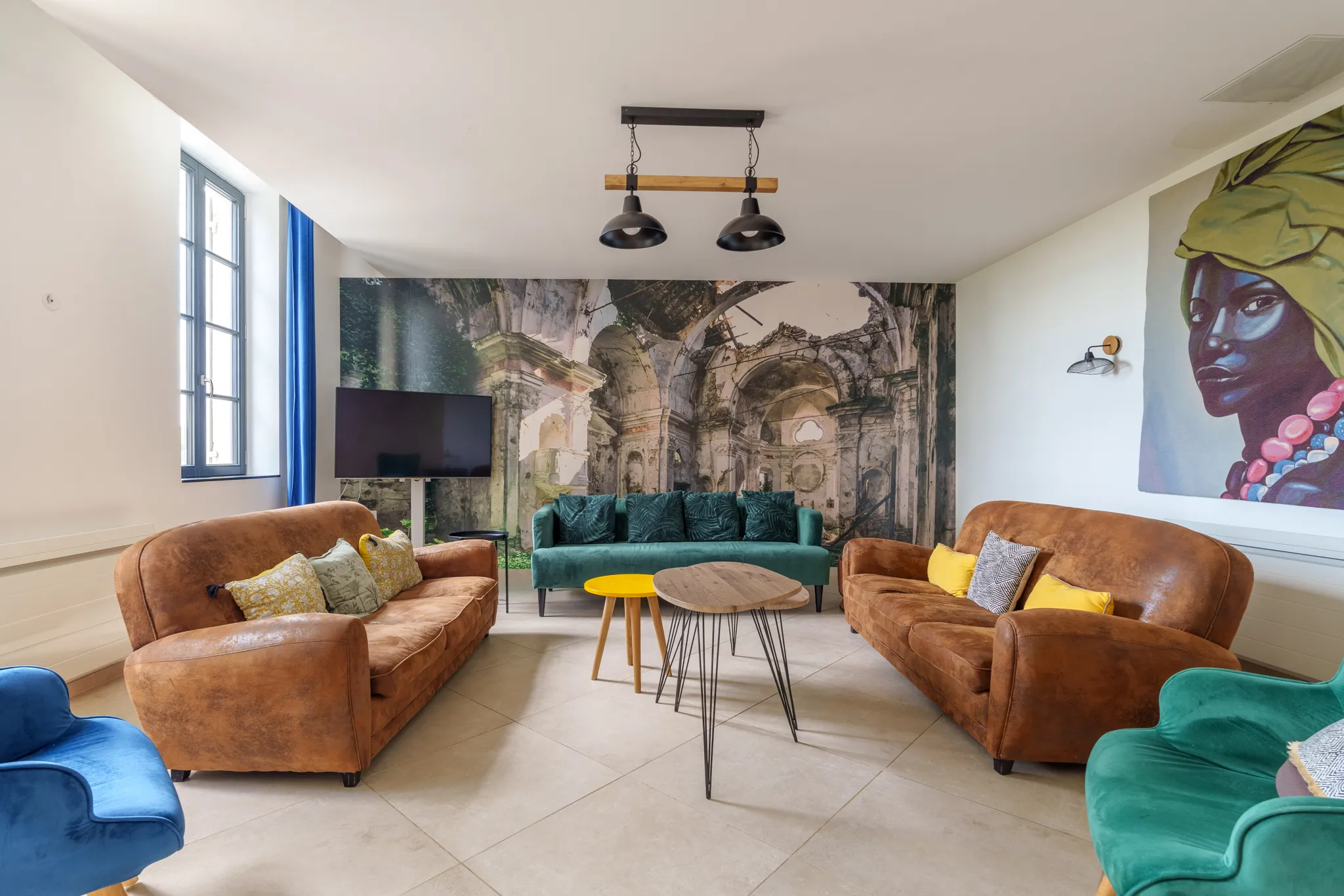 Pièce détente avec 3 canapés, grand portrait au mur