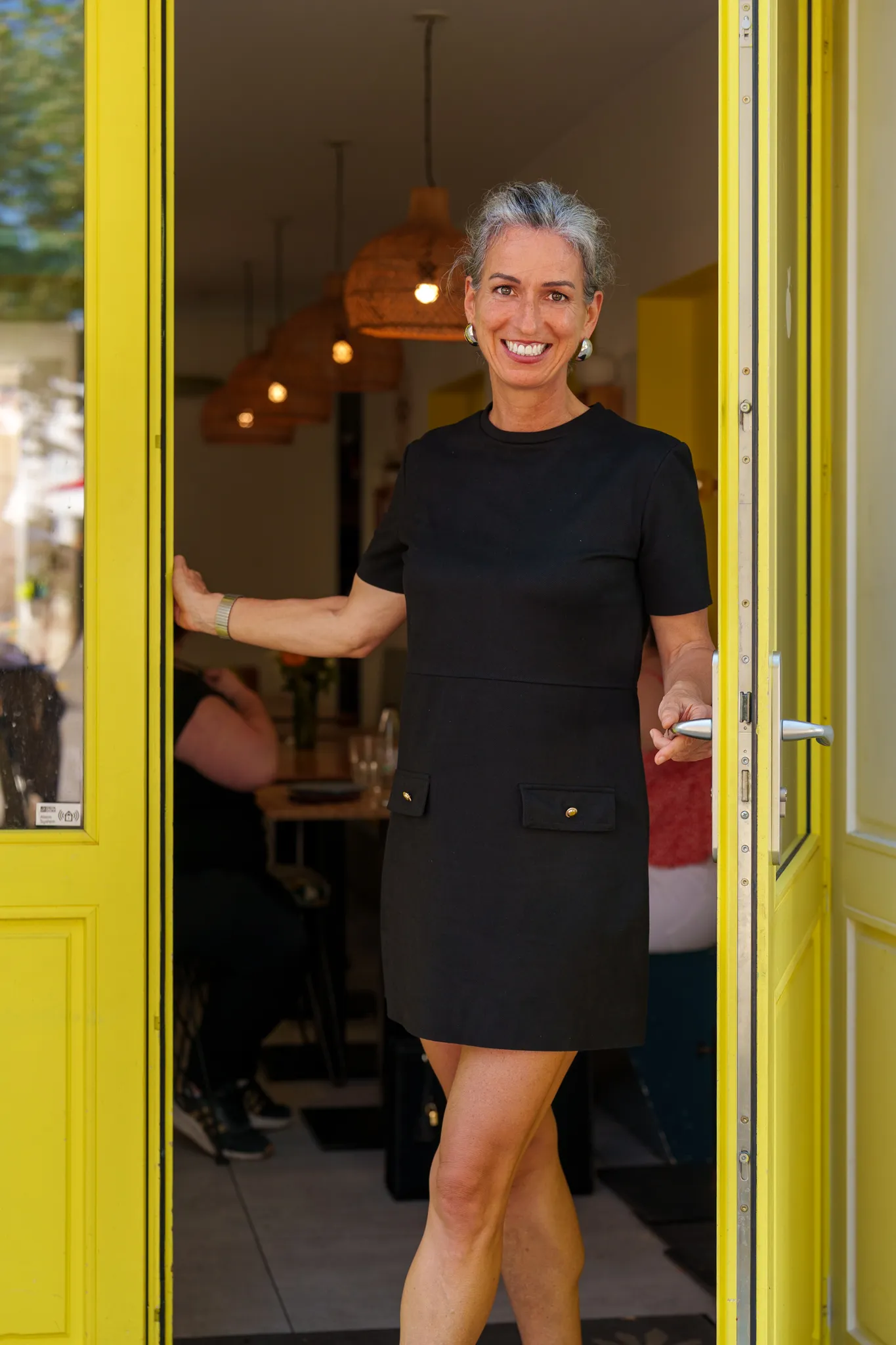 Consultante radieuse sur le pas de porte jaune