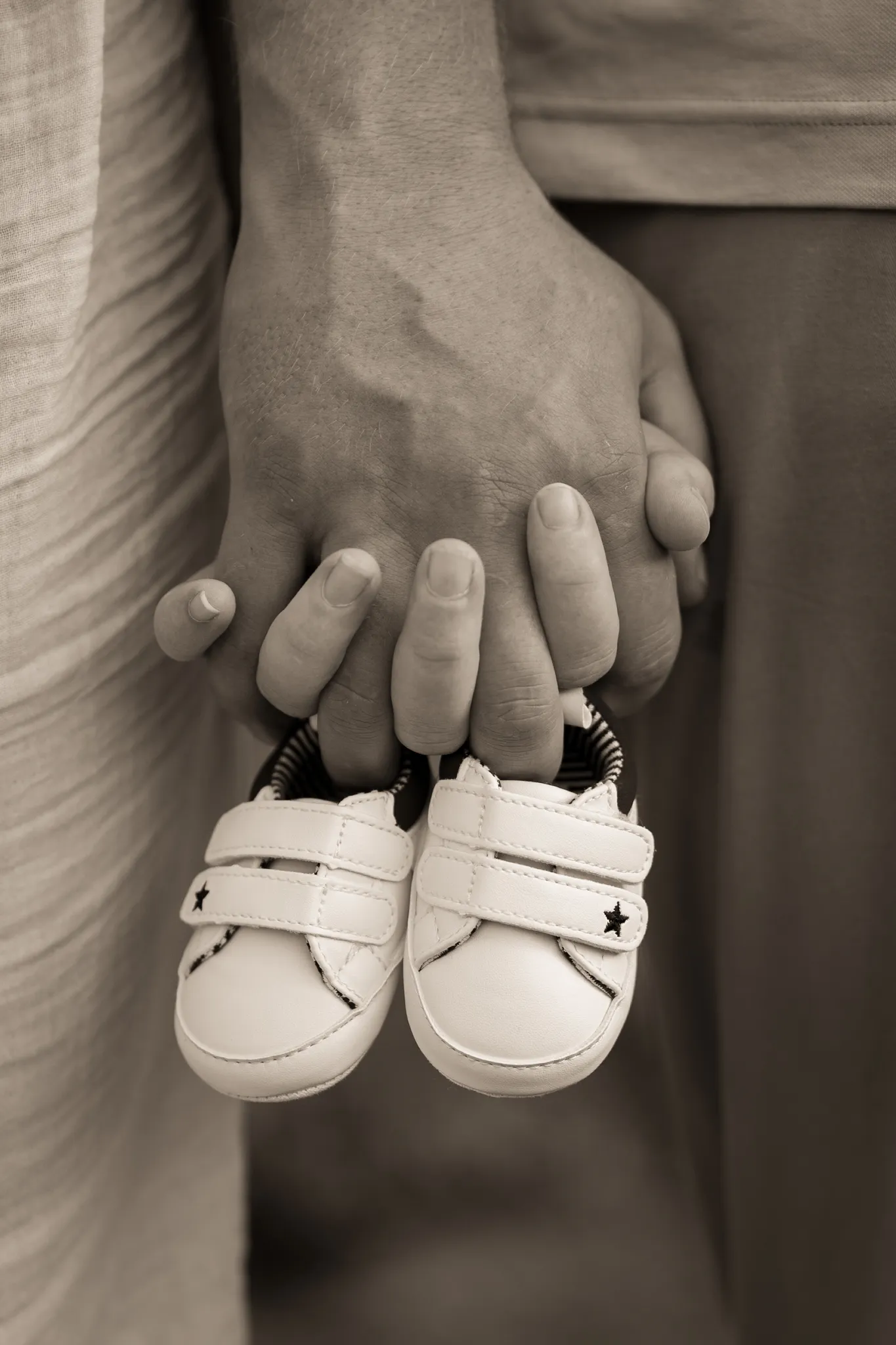 Mains d'un couple avec chaussures bébé