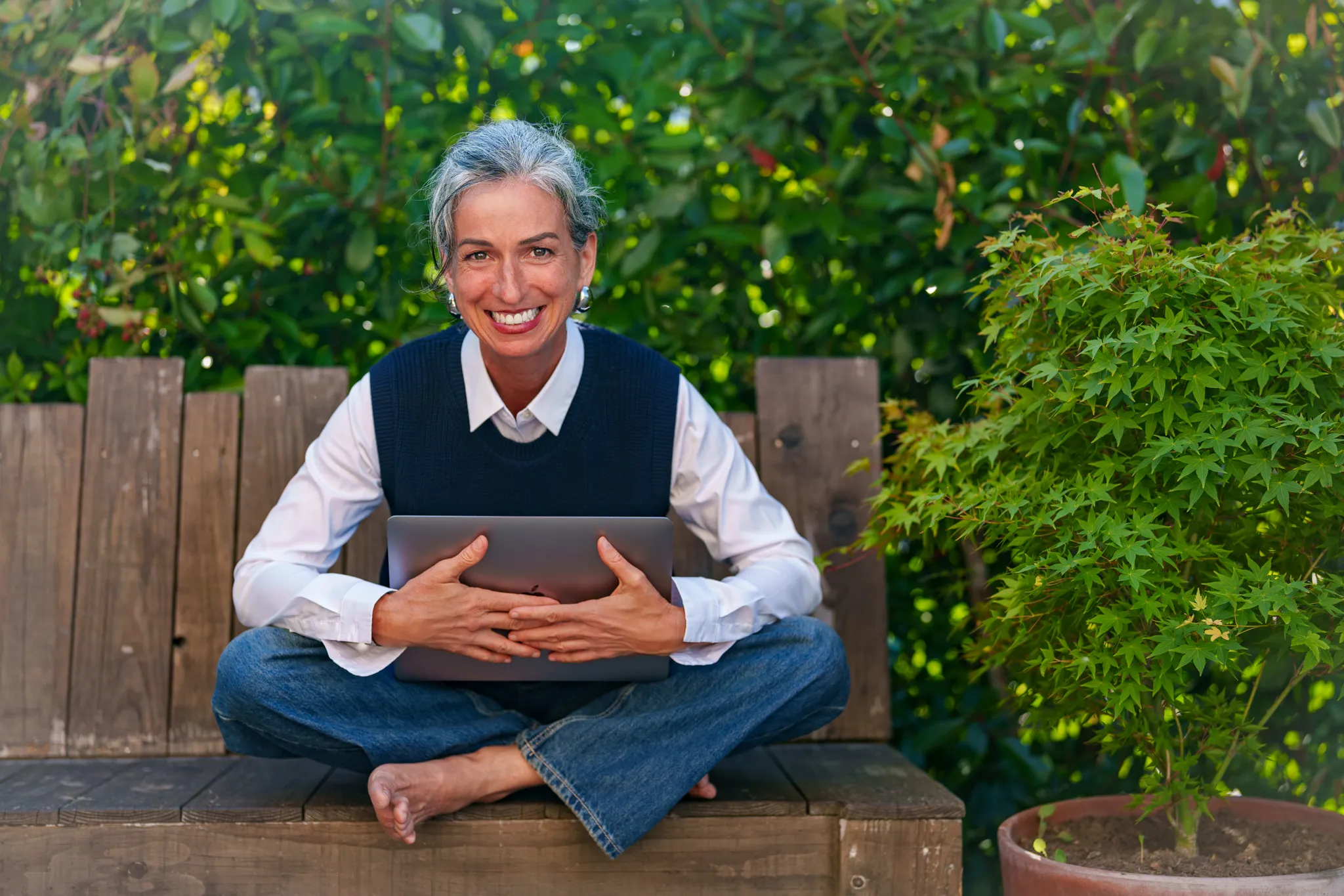 Coach assise sur un banc avec ordinateur