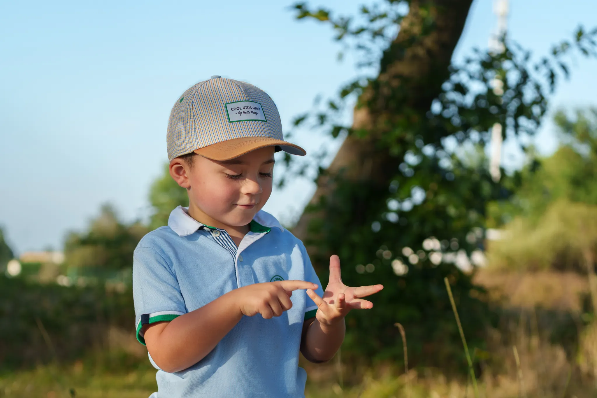 Petit garçon avec casquette qui compte sur ses doigts.