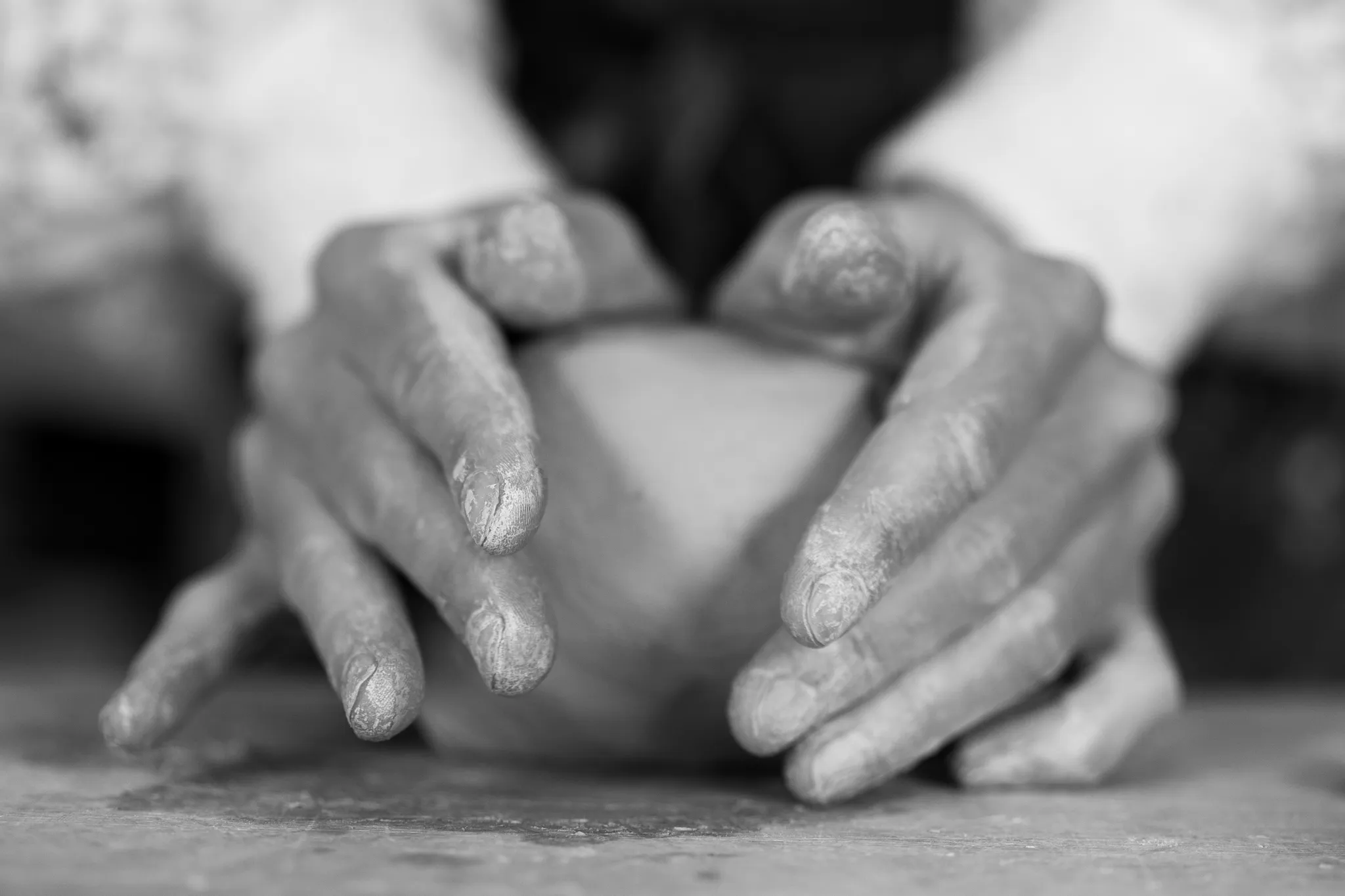 Gros plan sur le pétrissage manuel de l'argile fraîche dans un atelier de poterie.