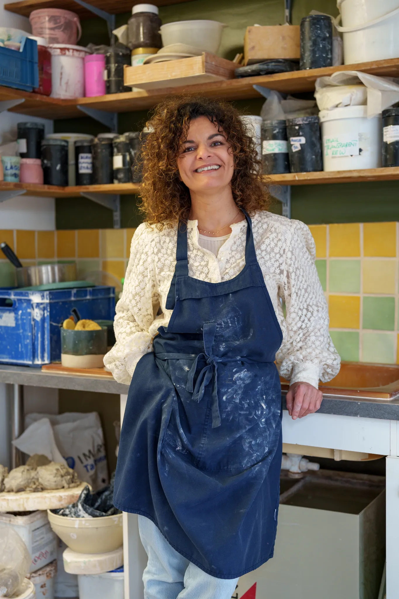 Céramiste souriante dans son atelier.