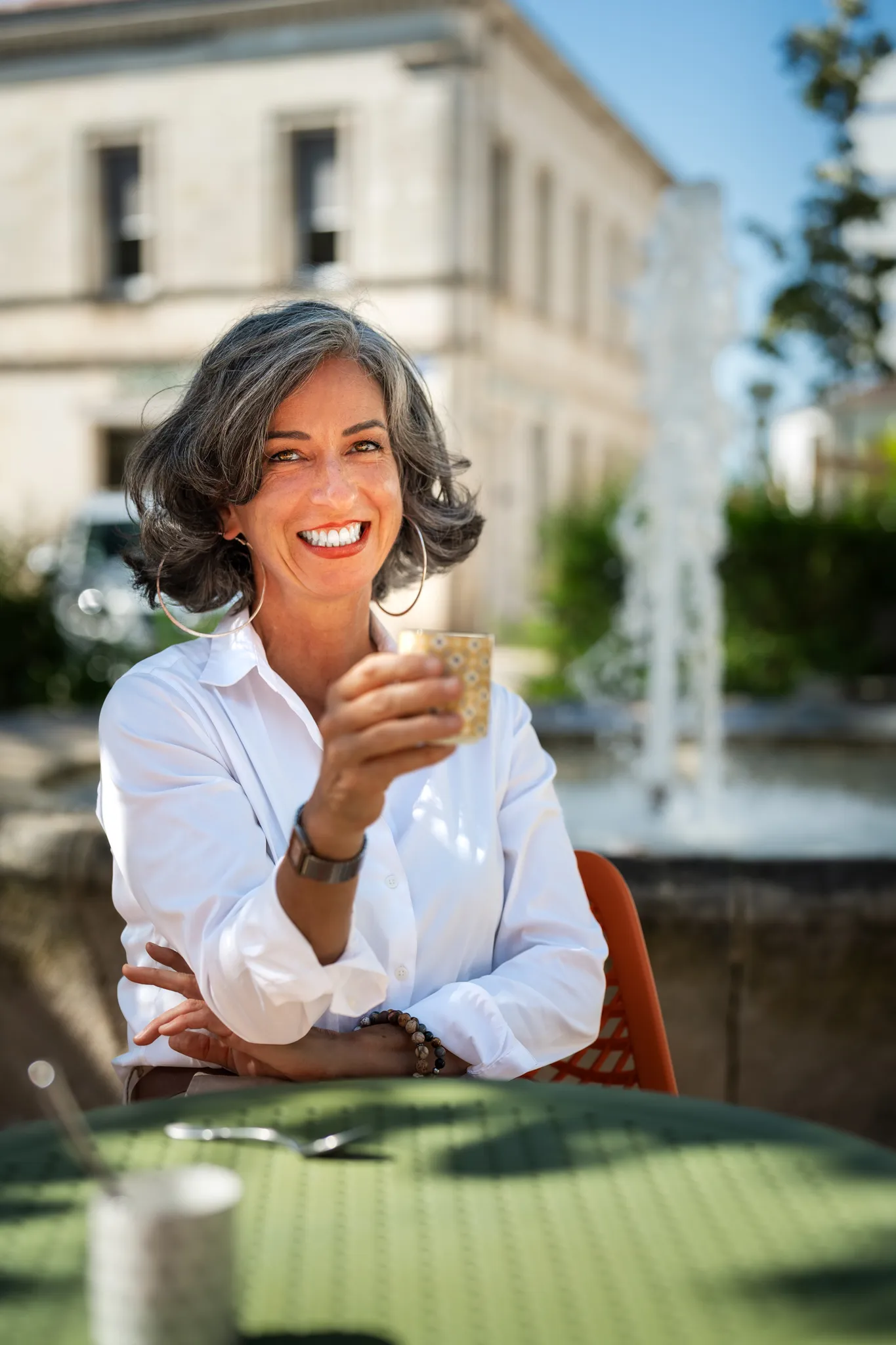 Entrepreneuse buvant un verre à une terrasse.